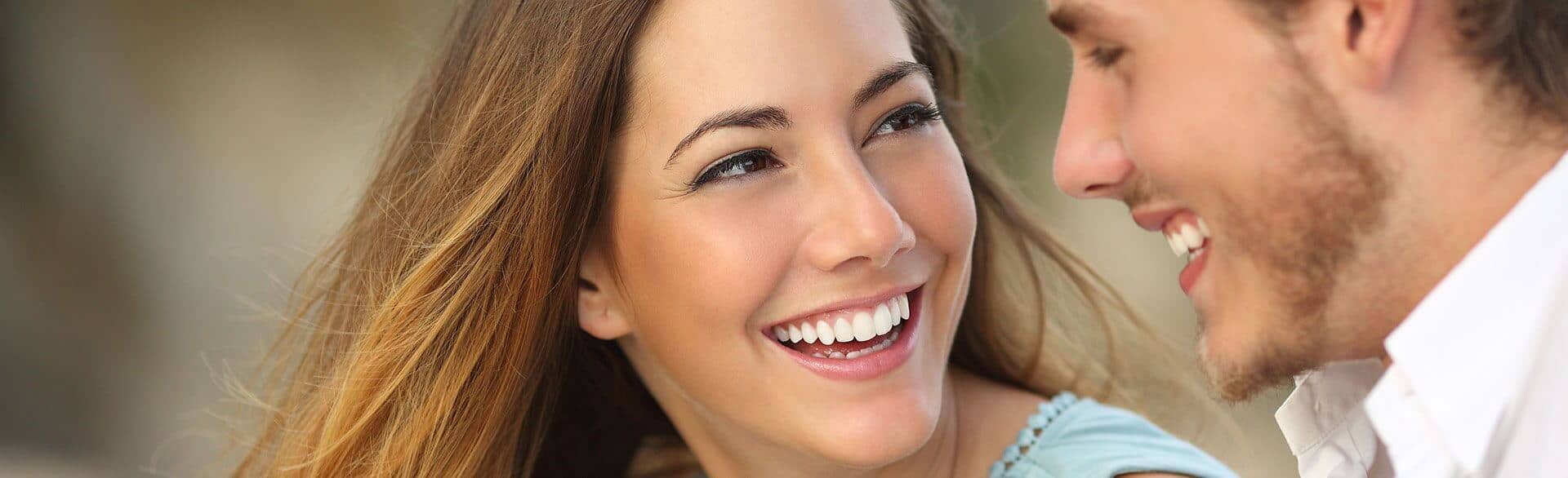 young couple with bright, white smiles