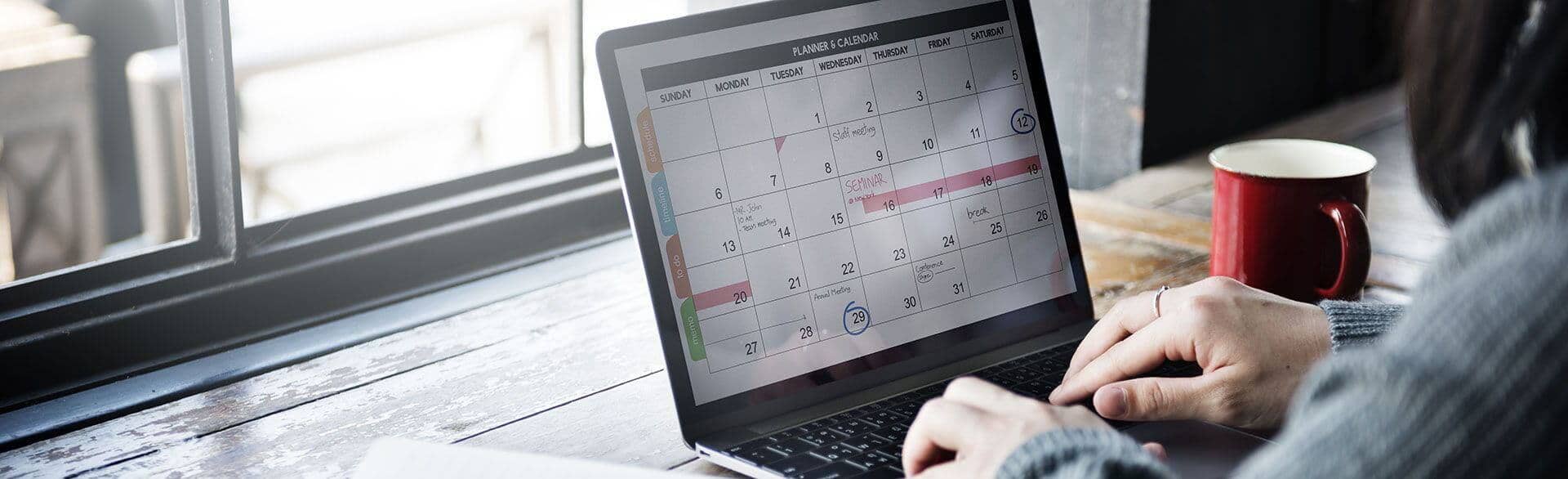 person looking at their schedule on their laptop