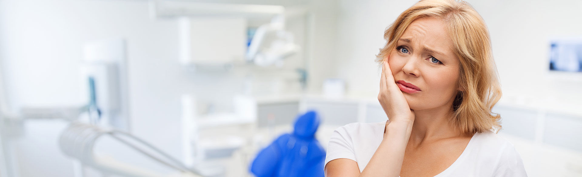 woman holding her jaw in pain