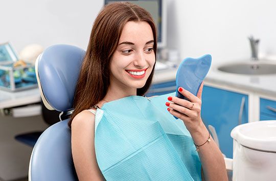woman admiring her smile in a mirror
