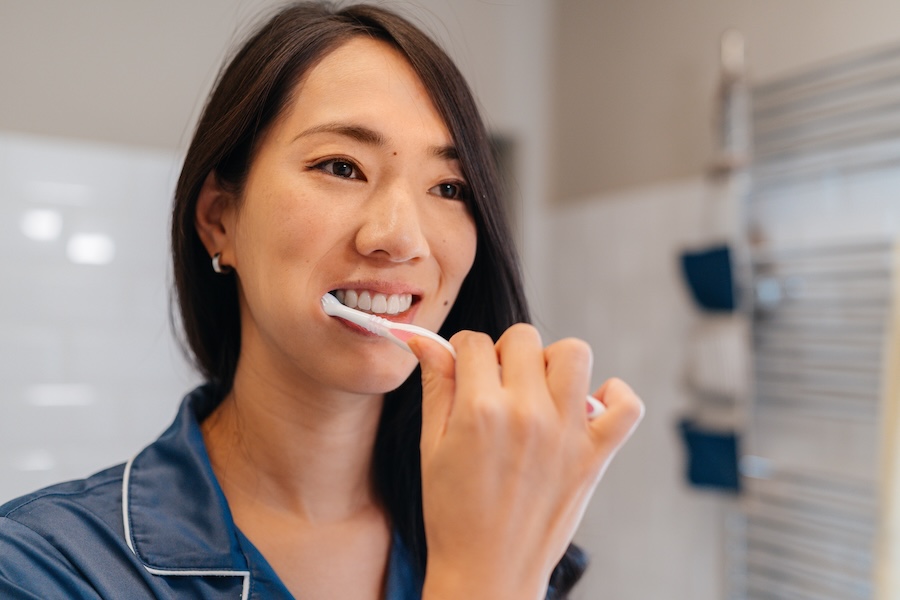 woman brushing her teeth for healthy dental habits to prevent cavities